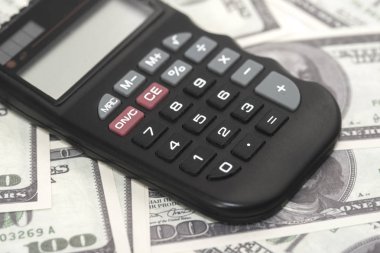 Birkaç dolar ve masa üzerinde bir hesap makinesi, finans ve tasarruf. İş konsepti