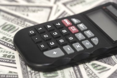 Birkaç dolar ve masa üzerinde bir hesap makinesi, finans ve tasarruf. İş konsepti