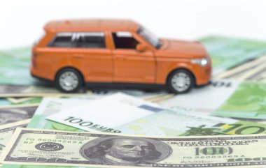 turuncu araba ve para, euro ve dolar. sigorta kavramı