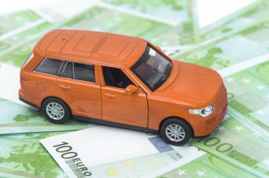 turuncu araba ve para, euro ve dolar. sigorta kavramı