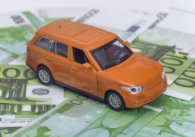 turuncu araba ve para, euro ve dolar. sigorta kavramı