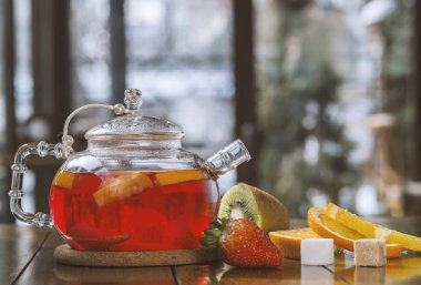 ahşap bir masada bir su ısıtıcısı meyve çayı .