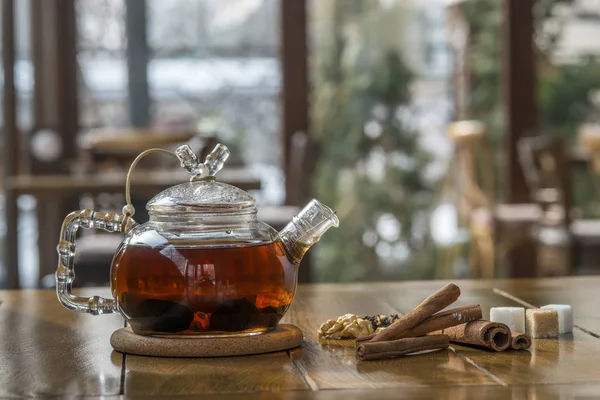 Чай с корицей в чайнике на деревянном столе . — стоковое фото