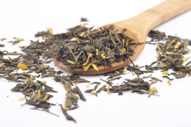 beyaz arka plan üzerinde izole ahşap bir kaşık üzerinde aromatik yeşil kuru çay,