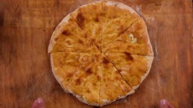HANDS OF A FEW PEOPLE TAKE CHEESE PIE, KHACHAPURI .Slow motion