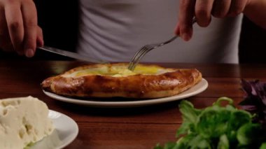 Man eat oriental dish. Adjarian khachapuri. Georgian  food