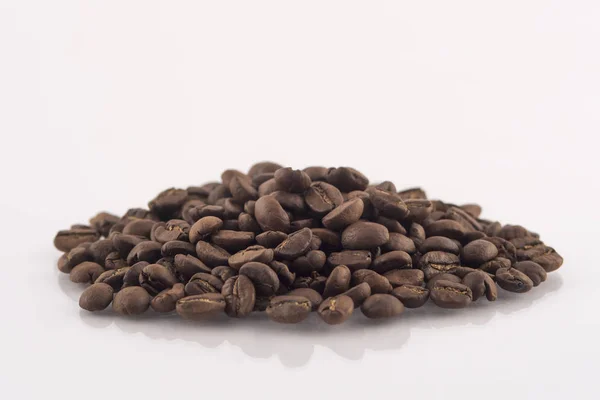 烘培的咖啡豆桩在白色背景上 — 图库照片