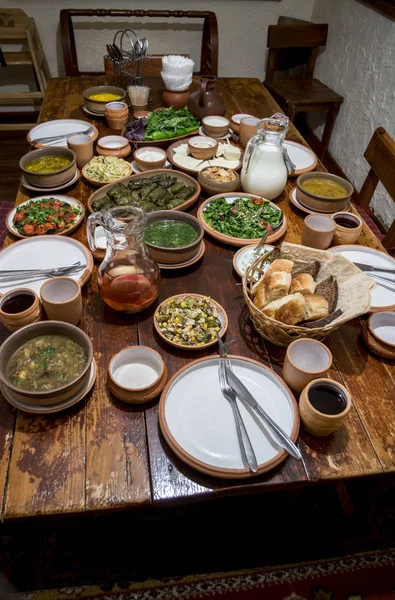 Varios platos en platos de cerámica sobre una mesa de madera servida en tr — Foto de Stock