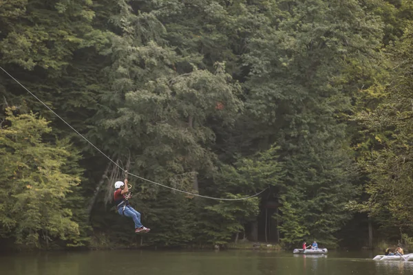 Zipline heyecan verici bir macera etkinliğidir. İpe asılan adam