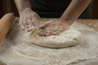 Fırıncı pizza hazırlama için hamur yoğurunur. Şef aşçı ahşap masada pasta pişirme için hamur yapma. Süreç hazırlık ev yapımı pasta. Pişirme makarna, spagetti, khachapuri, gıda concep