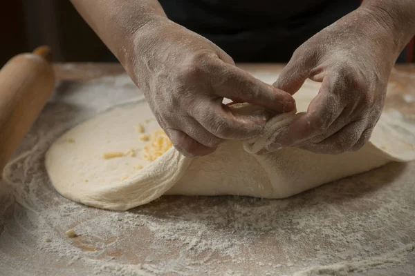 Baker kneading dough for pizza  preparation. Chef cook making dough for baking pie on wooden table. Process preparation homemade pastry. Cooking pasta, spaghetti,khachapuri, food concep