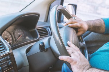 Araba kullanan adam. Kişi İngiltere, Japonya veya Hindistan'da sağ dan çekişli araba kullanıyor.