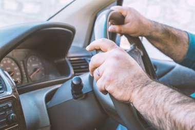 Araba kullanan adam. Kişi İngiltere, Japonya veya Hindistan'da sağ dan çekişli araba kullanıyor.