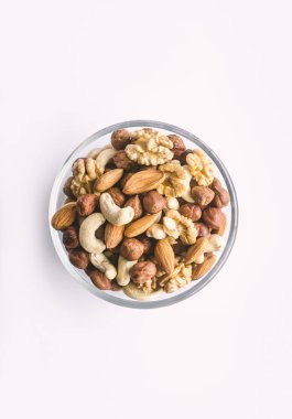Beyaz bir arka plan üzerinde bir kapta karışık fındık.