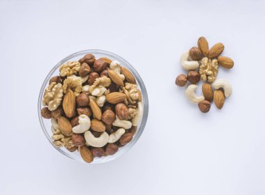 Beyaz bir arka plan üzerinde bir kapta karışık fındık.