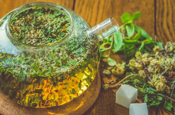 Чай с травами в чайнике на деревянном столе . — стоковое фото