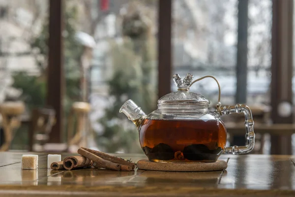 Tee mit Zimt in einer Teekanne auf einem Holztisch. — Stockfoto
