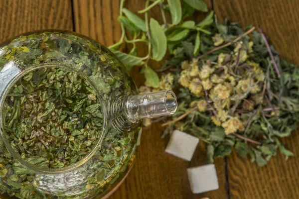 Teh dengan herbal dalam teko di atas meja kayu . — Stok Foto