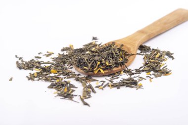 beyaz arka plan üzerinde izole ahşap bir kaşık üzerinde aromatik yeşil kuru çay,