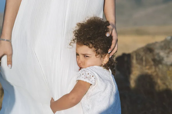 Ağlayan bebek anne bacağını açık havada tutuyor..