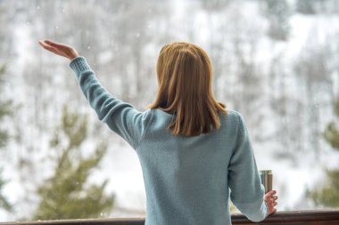 Sıcak bir içecekle termos tutan bir kız. Bir fincan kahve.
