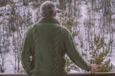 Sıcak bir içecekle termos tutan adam. H'sinde bir fincan kahve