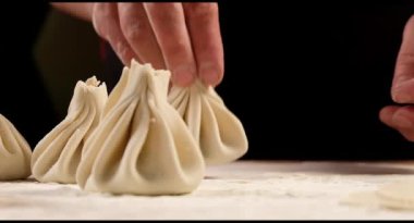 Aşçı ahşap masada khinkali yapıyor. İşlem hazırlığı Gürcistan yemeği. yiyecek konsepti.