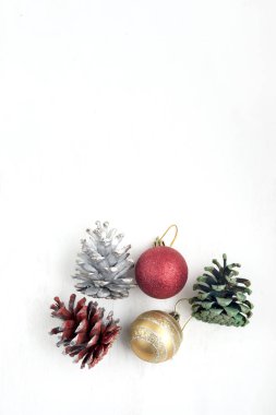 Beyaz arka planda Noel oyuncakları ve renkli koniler