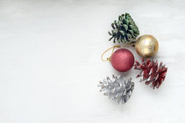 Beyaz arka planda Noel oyuncakları ve renkli koniler