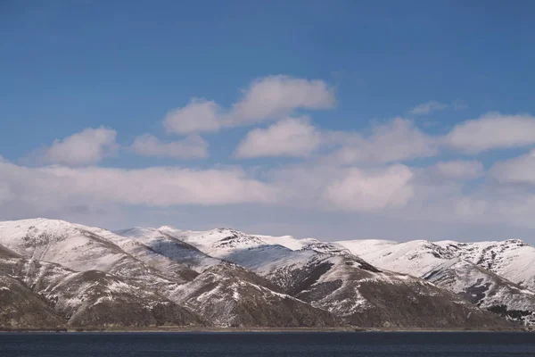 Gyönyörű kilátás a tóra és a hegyekre a hó. Örményország, Sev — Stock Fotó