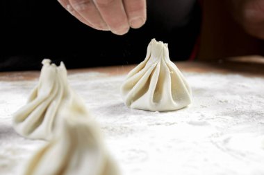 Aşçı ahşap masada khinkali yapıyor. İşlem hazırlığı Gürcistan yemeği. yiyecek konsepti.