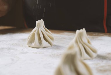 Aşçı ahşap masada khinkali yapıyor. İşlem hazırlığı Gürcistan yemeği. yiyecek konsepti.