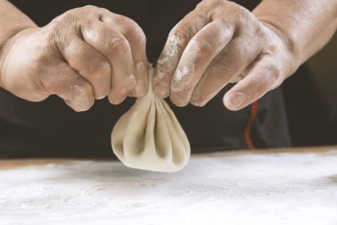 Aşçı ahşap masada khinkali yapıyor. İşlem hazırlığı Gürcistan yemeği. yiyecek konsepti.