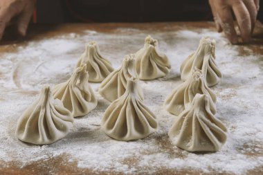 Aşçı ahşap masada khinkali yapıyor. İşlem hazırlığı Gürcistan yemeği. yiyecek konsepti.