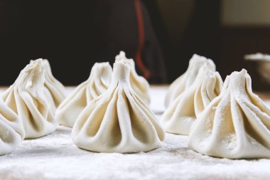 Aşçı ahşap masada khinkali yapıyor. İşlem hazırlığı Gürcistan yemeği. yiyecek konsepti.