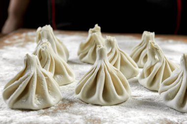 Aşçı ahşap masada khinkali yapıyor. İşlem hazırlığı Gürcistan yemeği. yiyecek konsepti.