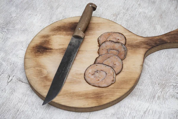 meatloaf and knife on a cutting board on a white wooden table