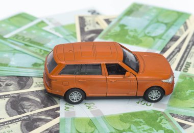 turuncu araba ve para, euro ve dolar. sigorta kavramı