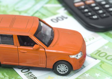 turuncu araba ve para, euro ve dolar. sigorta kavramı