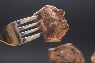 Çatal, koyu arka plan üzerinde et parçası