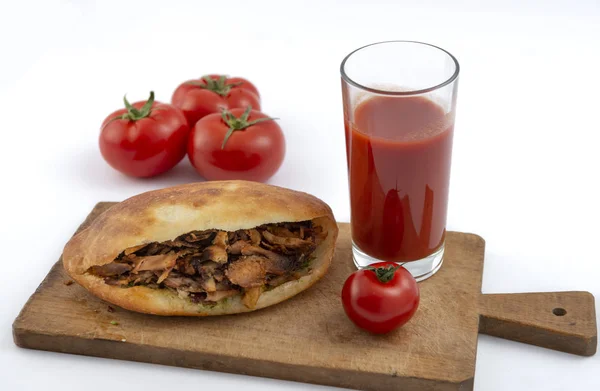 shawarma in pita bread ,tomatoes and tomato juice on a white background.doner kebab