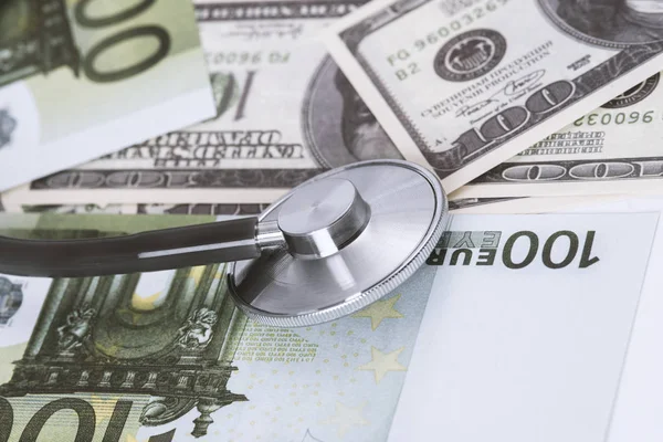 medical stethoscope on dollars and euro banknotes