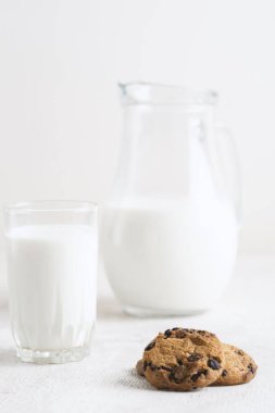 Süt ve çikolata parçalı kurabiyeler beyaz ahşap arka plan fotokopi alanı üzerinde.