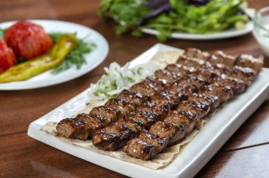 Fast food. Doğu yemekleri. Şiş kebap, lyulya-kebap. Yeşillik, sebze ve sosla süslenmiş doğu mutfağı yemekleri.