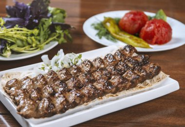 Fast food. Doğu yemekleri. Şiş kebap, lyulya-kebap. Yeşillik, sebze ve sosla süslenmiş doğu mutfağı yemekleri.
