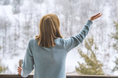Sıcak bir içecekle termos tutan bir kız. Bir fincan kahve.