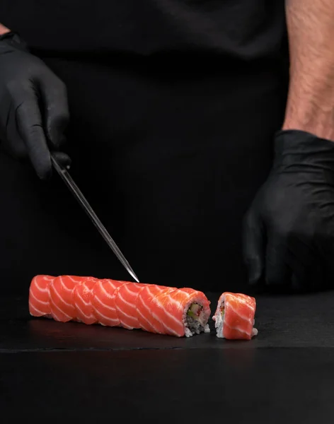Cook hands making sushi roll closeup photo