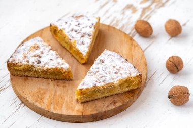 Ahşap zemin üzerinde ceviz olan elmalı turta parçaları.