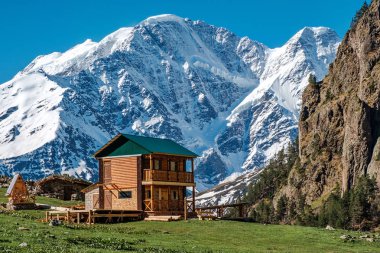 Dağlardaki ev. Elbrus bölgesi. Arka planda, yedi numara şeklinde buzul.