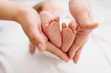 Anne ne kadar küçük olduklarını gösteren bebeğin ayak tutar